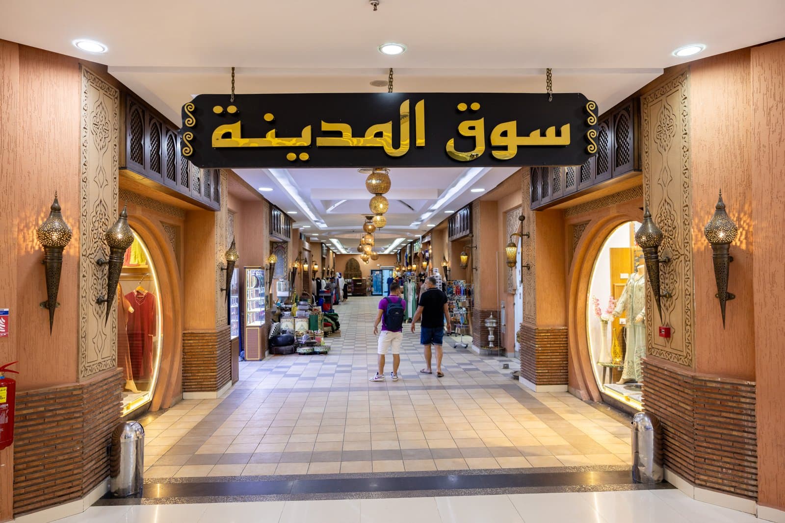 Promenade de souk marocain eclairee aux lanternes, echoppes d'artisans, lueur ambree